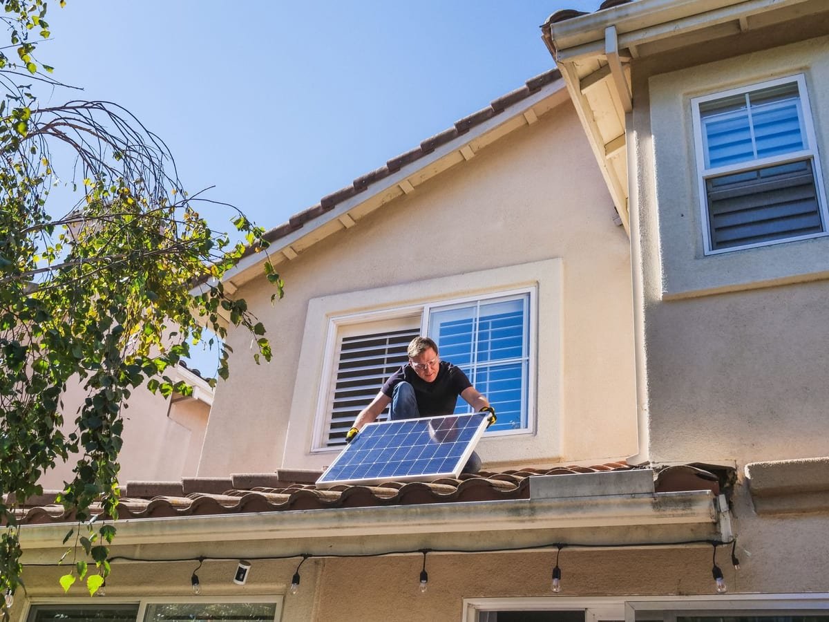 Profissional inspecionando um módulo fotovoltaico em cima de um telhado