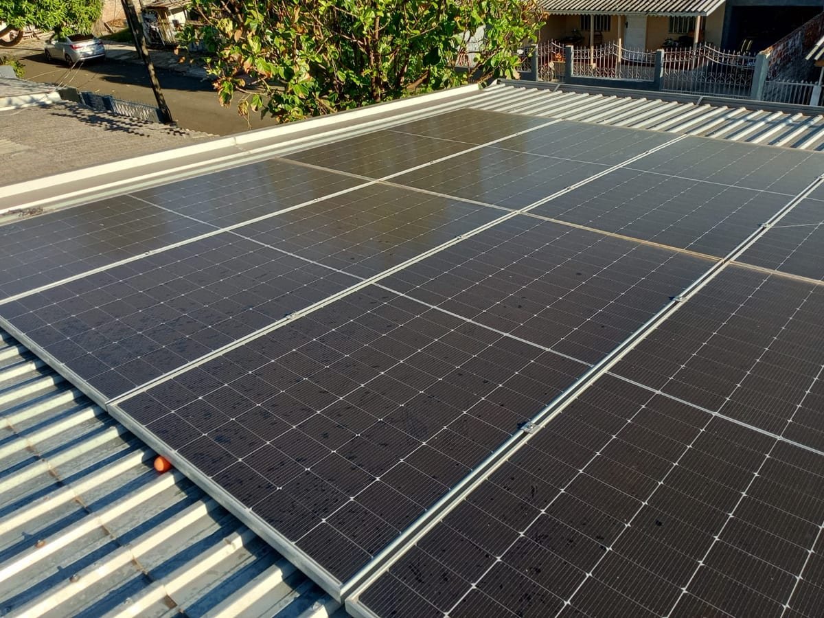 Sistema fotovoltaico residencial visto de cima, sobre telhado de telha metálica